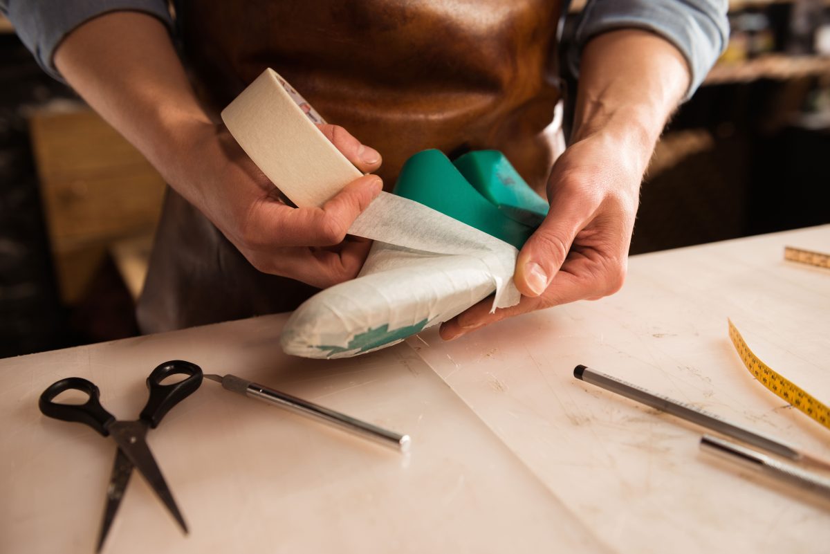 Close up of a cobbler modeling mens shoe at his workshop